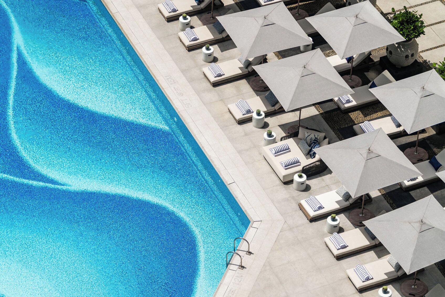 A poolside area with lounge chairs and umbrellas.