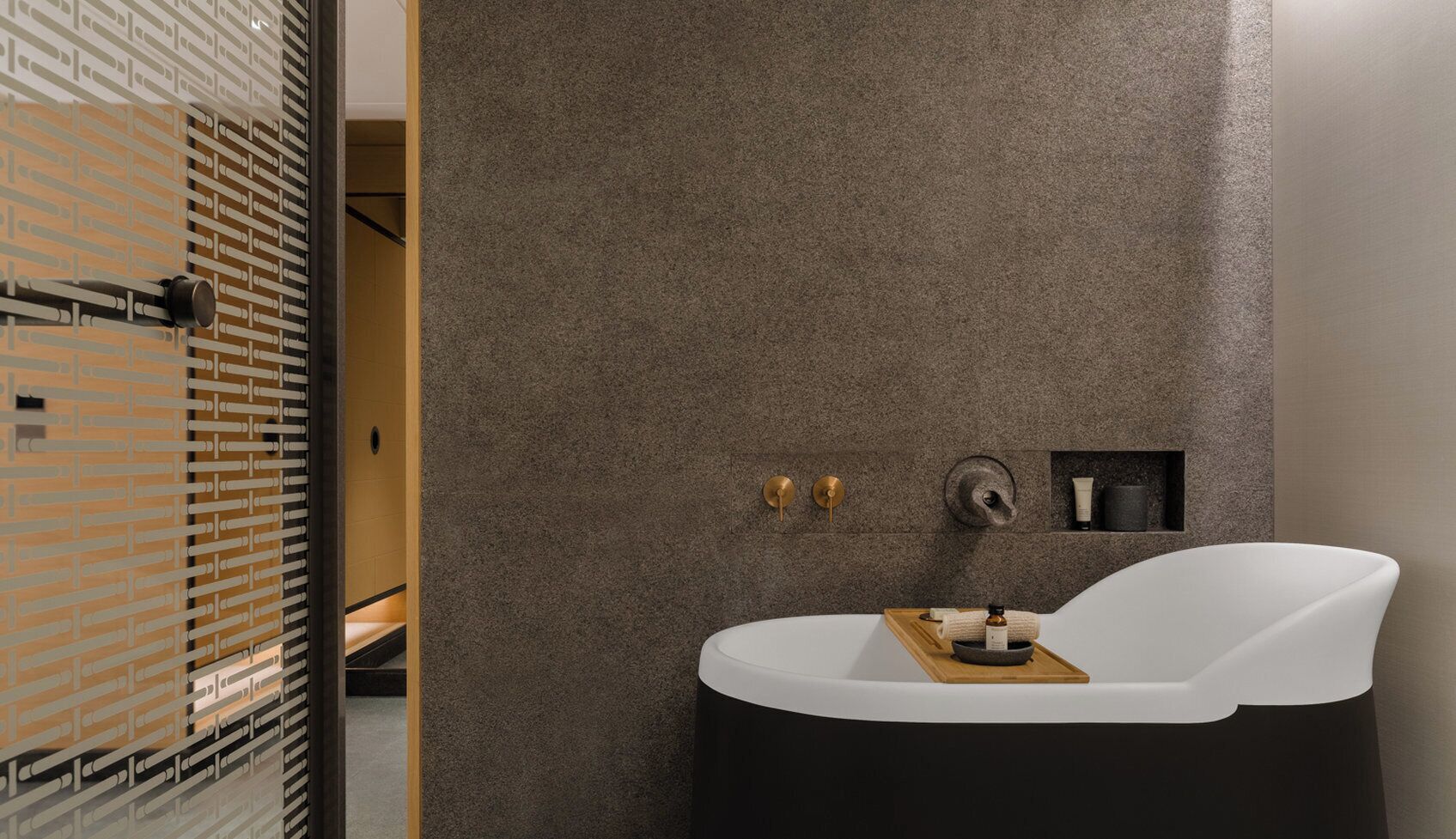 Un baño moderno con una bañera independiente, un perchero y un estante pequeño con artículos de tocador.