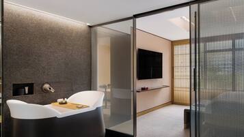 Une salle de bain moderne avec une baignoire sur pieds, un porte-serviettes et une petite étagère contenant des articles de toilette.