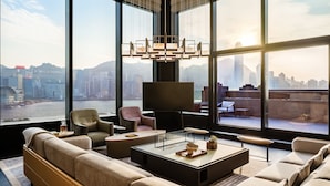 A modern living room with a city view, large windows, and contemporary furniture. - Regent Hong Kong (Kowloon)
