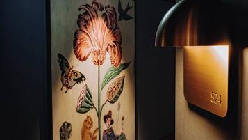 A wall-mounted light fixture with a number "524" and a colorful mural with butterflies and a tiger.