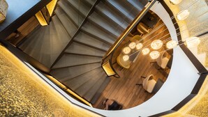 A spiral staircase with a modern design, wooden flooring, and contemporary lighting fixtures. - Prince Albert Lyon Bercy (Paris)