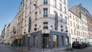 A multi-story hotel with a classic European architectural style, featuring a prominent entrance with a glass door and a sign indicating it is a hotel. - Prince Albert Lyon Bercy (Paris)