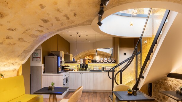 A modern interior with a kitchen, dining area, and staircase. - Prince Albert Lyon Bercy (Paris)