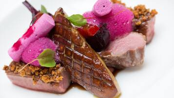 A dish with various food items including meat, vegetables, and garnishes.