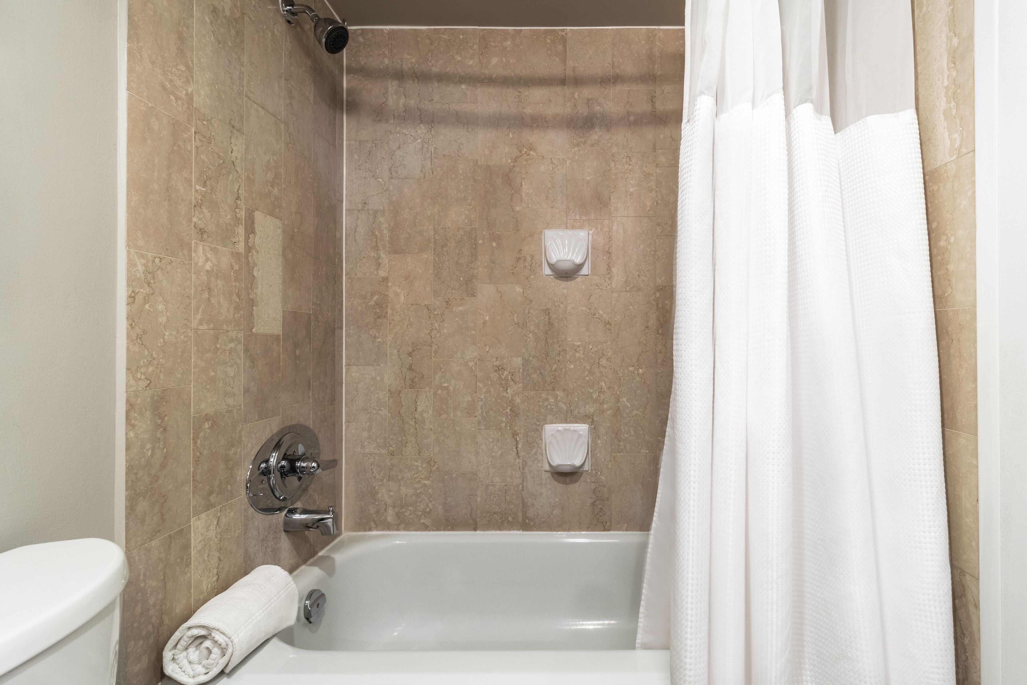 Un bagno con una vasca, un water e una tenda da doccia.
