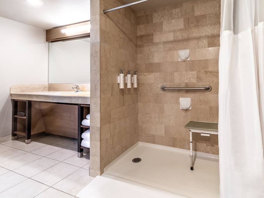 A modern bathroom with a shower, a sink, and a toilet.
