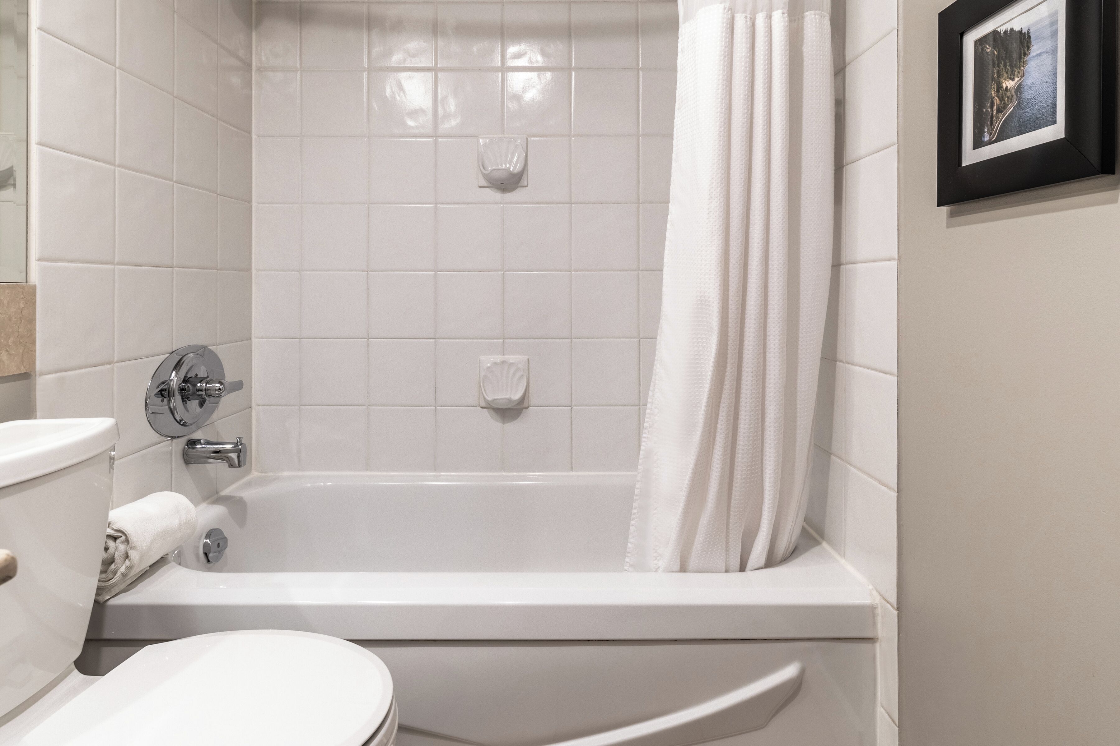 Un baño con bañera blanca, inodoro y lavamanos.
