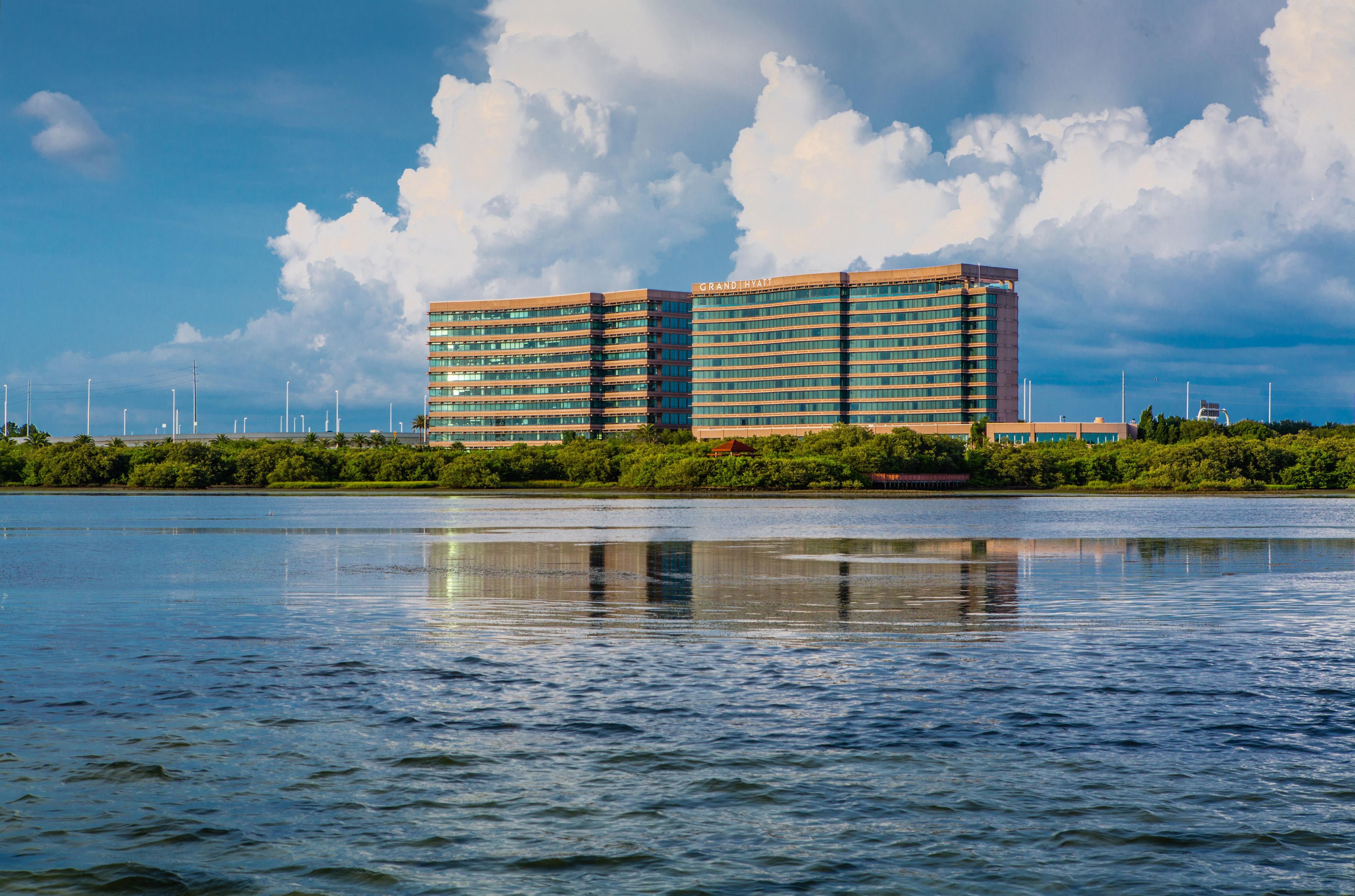 A multi-story hotel with a modern architectural design, situated by a body of water.