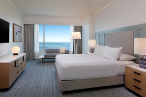 A hotel room with a large bed, two bedside tables, a sofa, a TV, and a view of the sea. - Grand Hyatt Tampa Bay (Tampa)