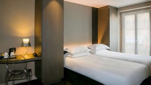 A hotel room with two beds, a desk with a lamp, a chair, and a large window. - Best Western Quartier Latin Pantheon (Paris)