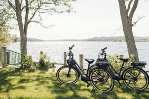 Una bicicleta aparcada junto a un sendero a orillas del lago, con árboles y vistas al agua.