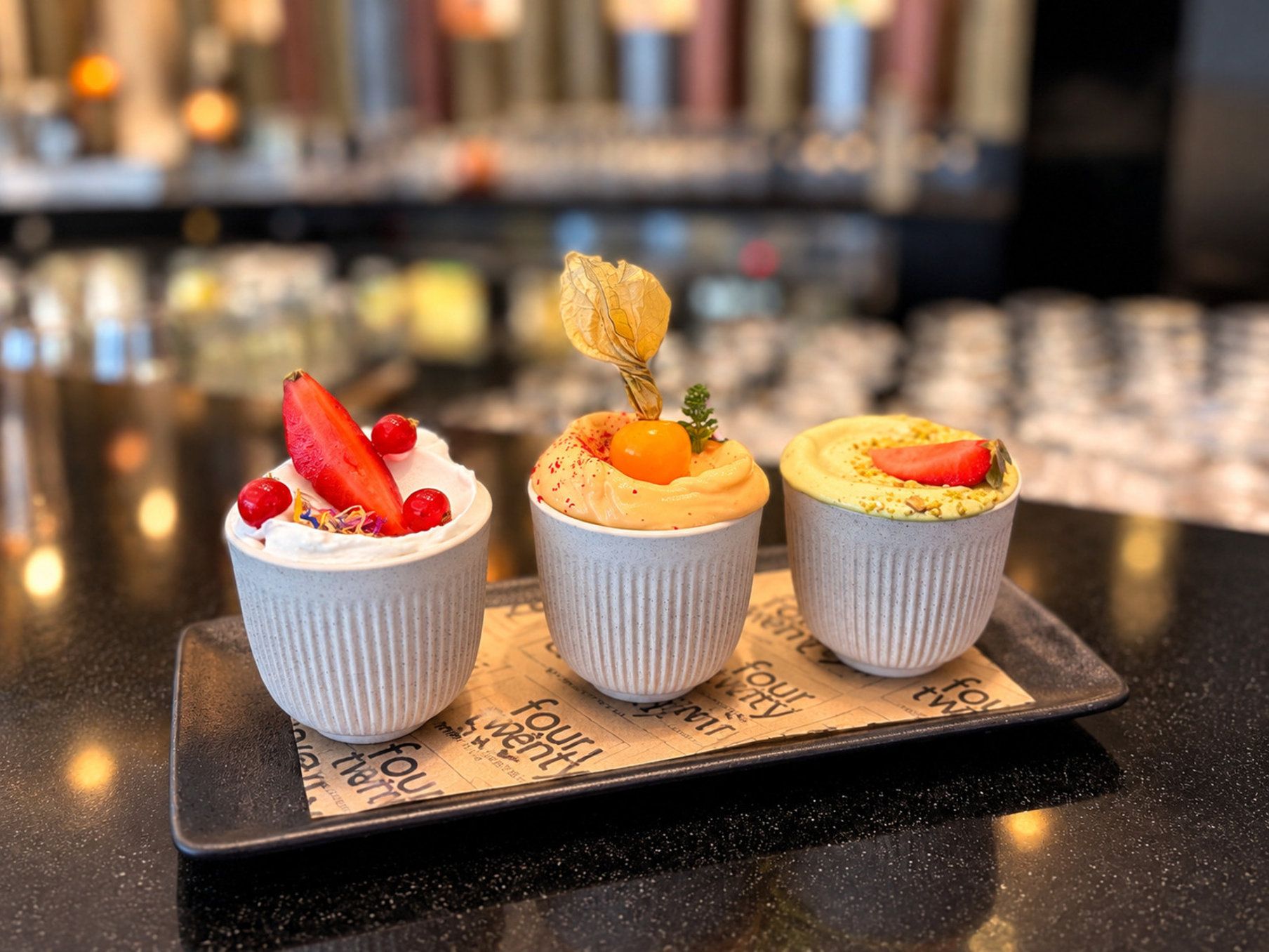 Three cupcakes on a tray with a newspaper underneath.