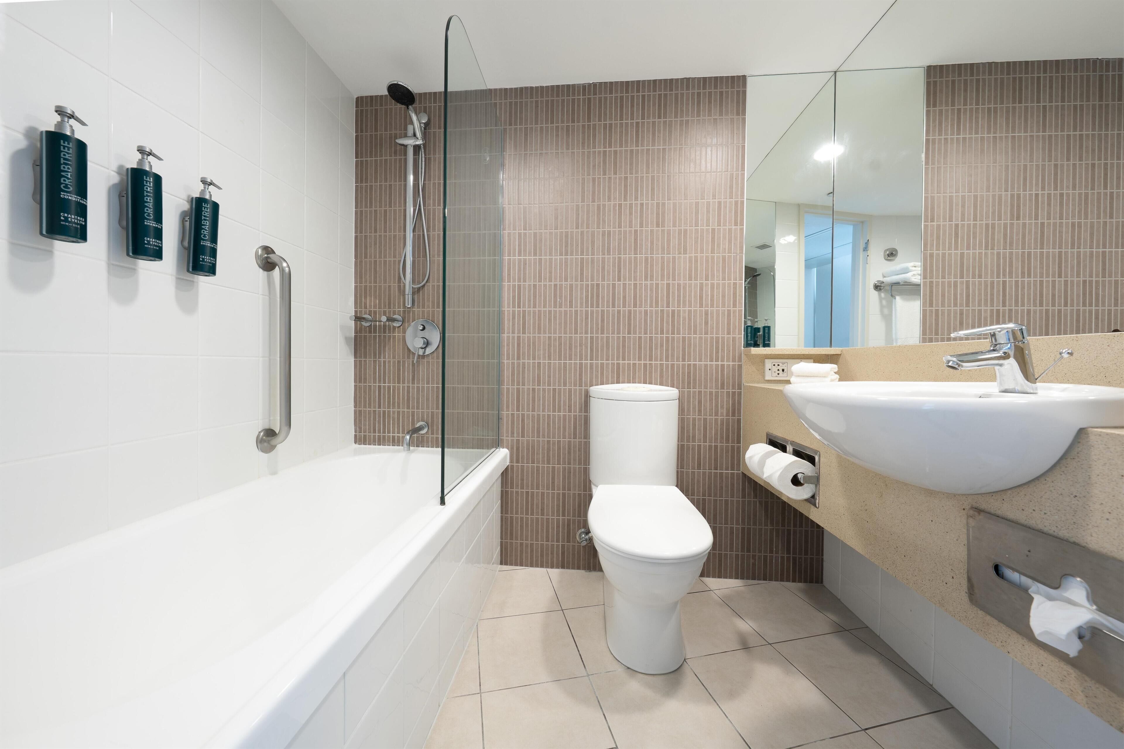 A modern bathroom with a bathtub, toilet, and sink.