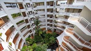 A multi-level atrium with balconies, indoor plants, and a central water feature. - DoubleTree by Hilton Hotel Cairns (Cairns)