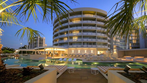 A hotel with a pool area, multiple balconies, and a well-lit exterior. - DoubleTree by Hilton Hotel Cairns (Cairns)