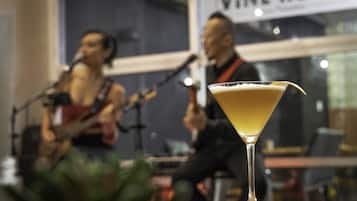 Una copa de martini sobre una mesa, con una banda tocando de fondo.
