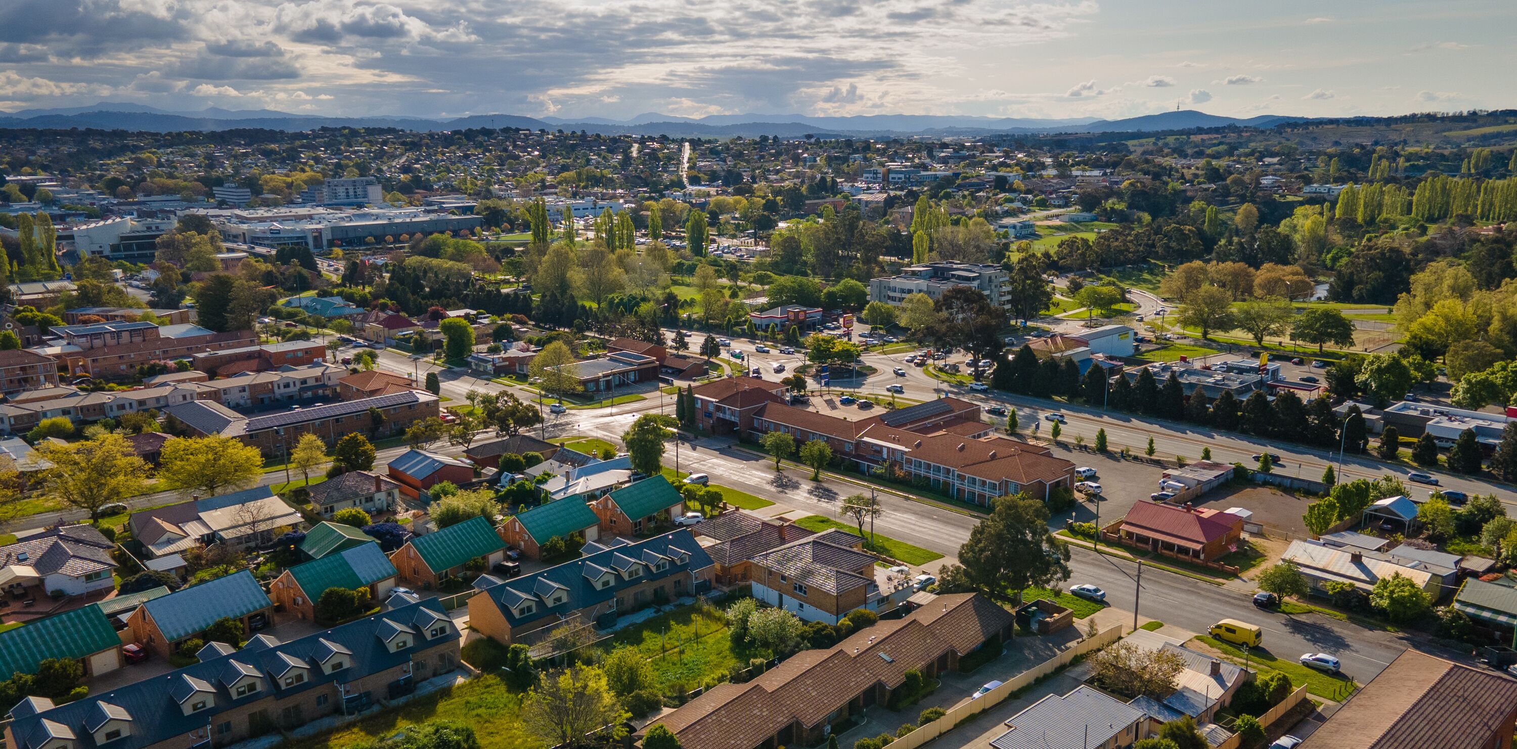 Vue aérienne d’un quartier résidentiel avec des maisons, des routes et de la végétation.