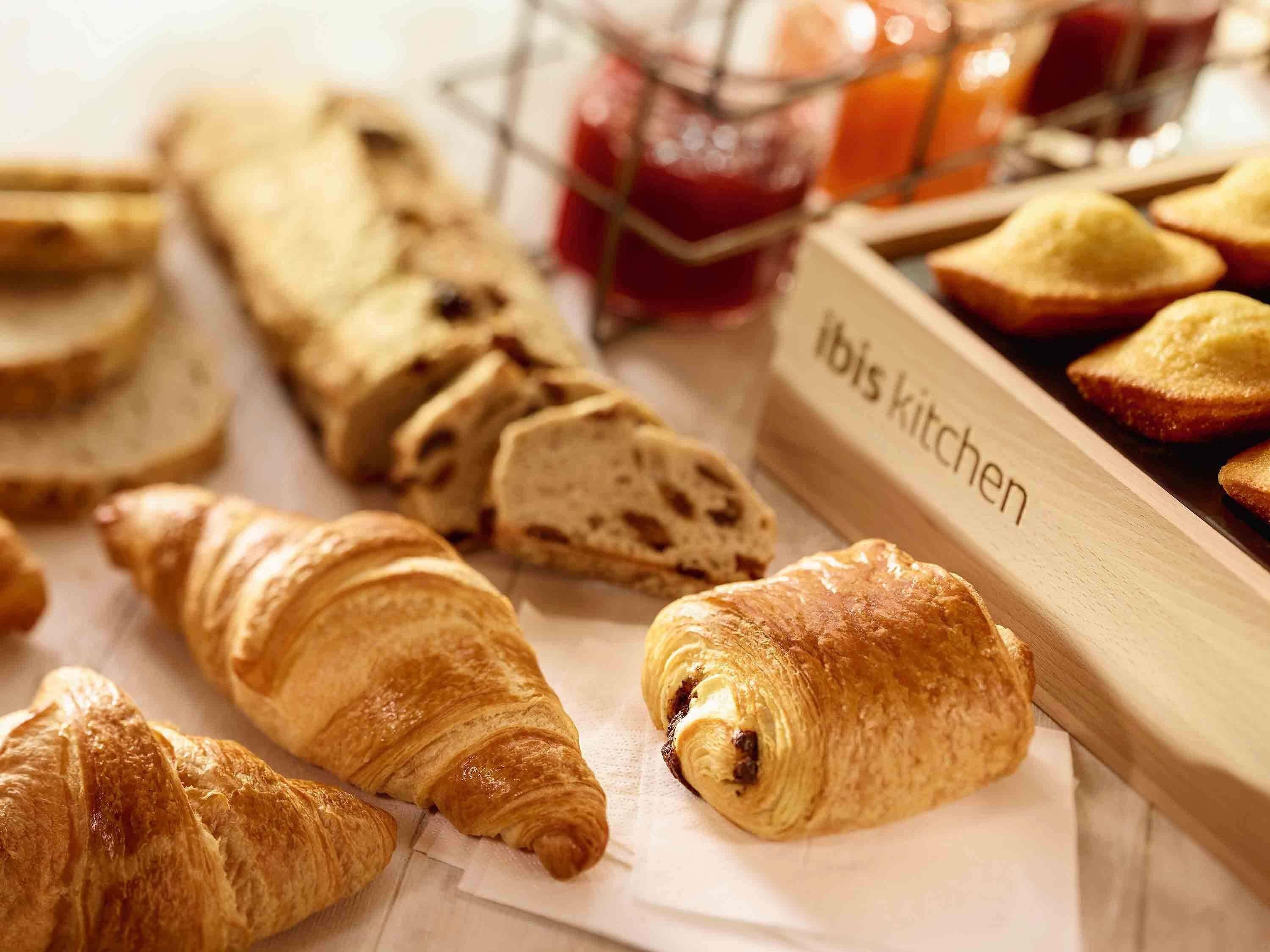 Une variété de produits de boulangerie, notamment des croissants et du pain, avec une étiquette indiquant « Cuisine ibis ».