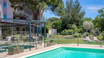 Alberca al aire libre, sombrillas en la alberca y camastros