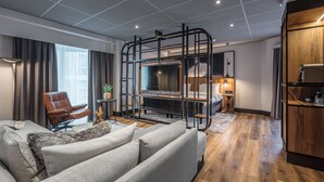Una sala moderna con un sofá, un televisor y un aparador de madera.