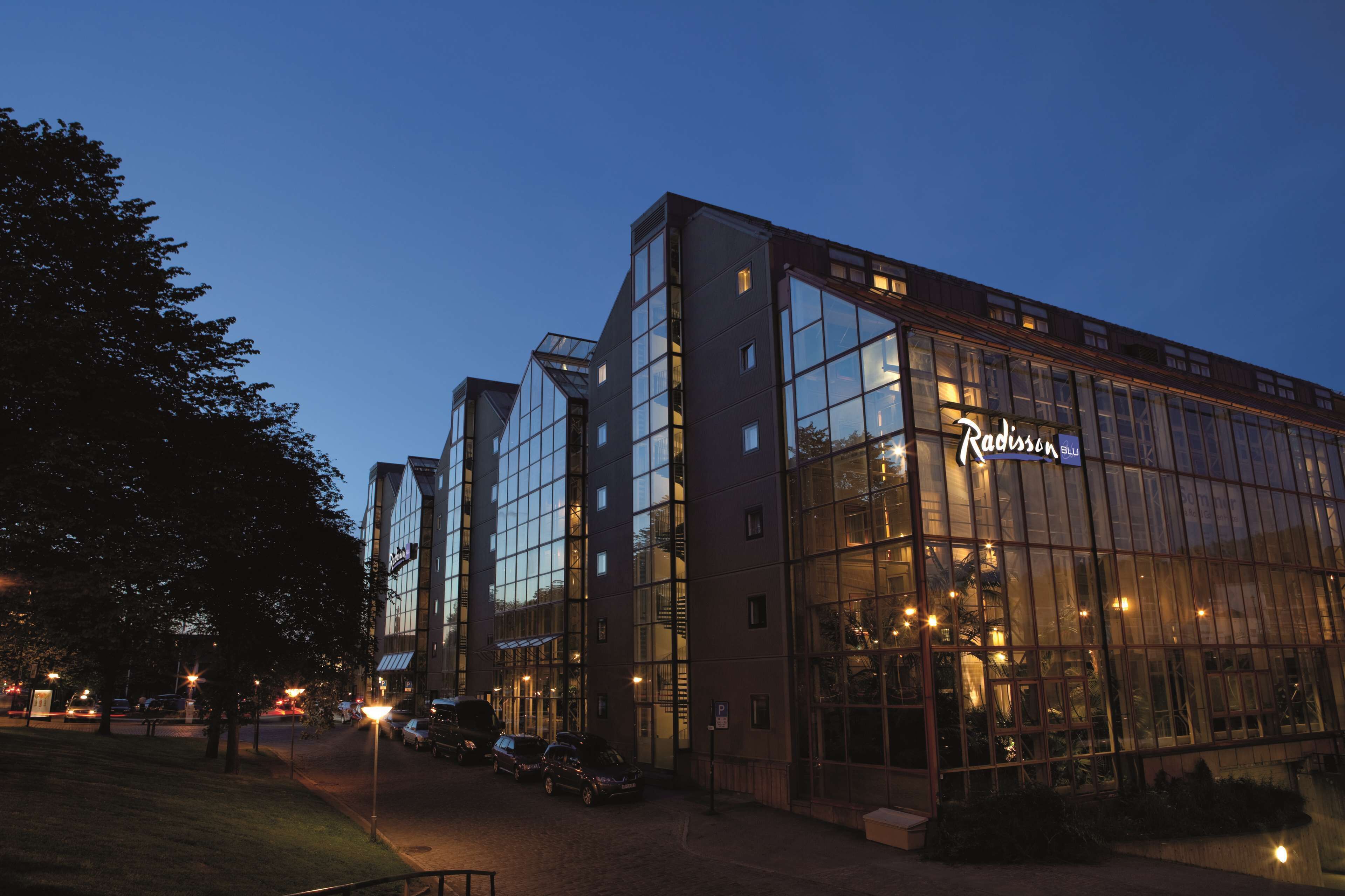 A modern building with large glass windows and a sign that reads "Radisson."