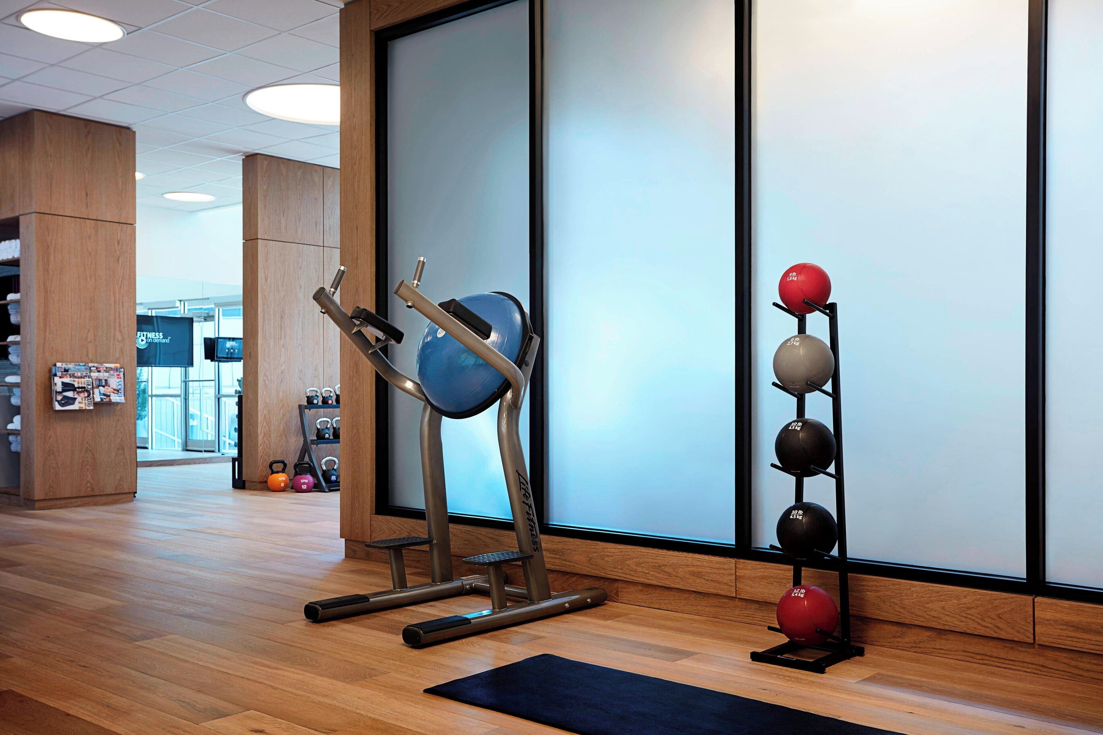 A gym with exercise equipment, a rack of weights, and a yoga mat.