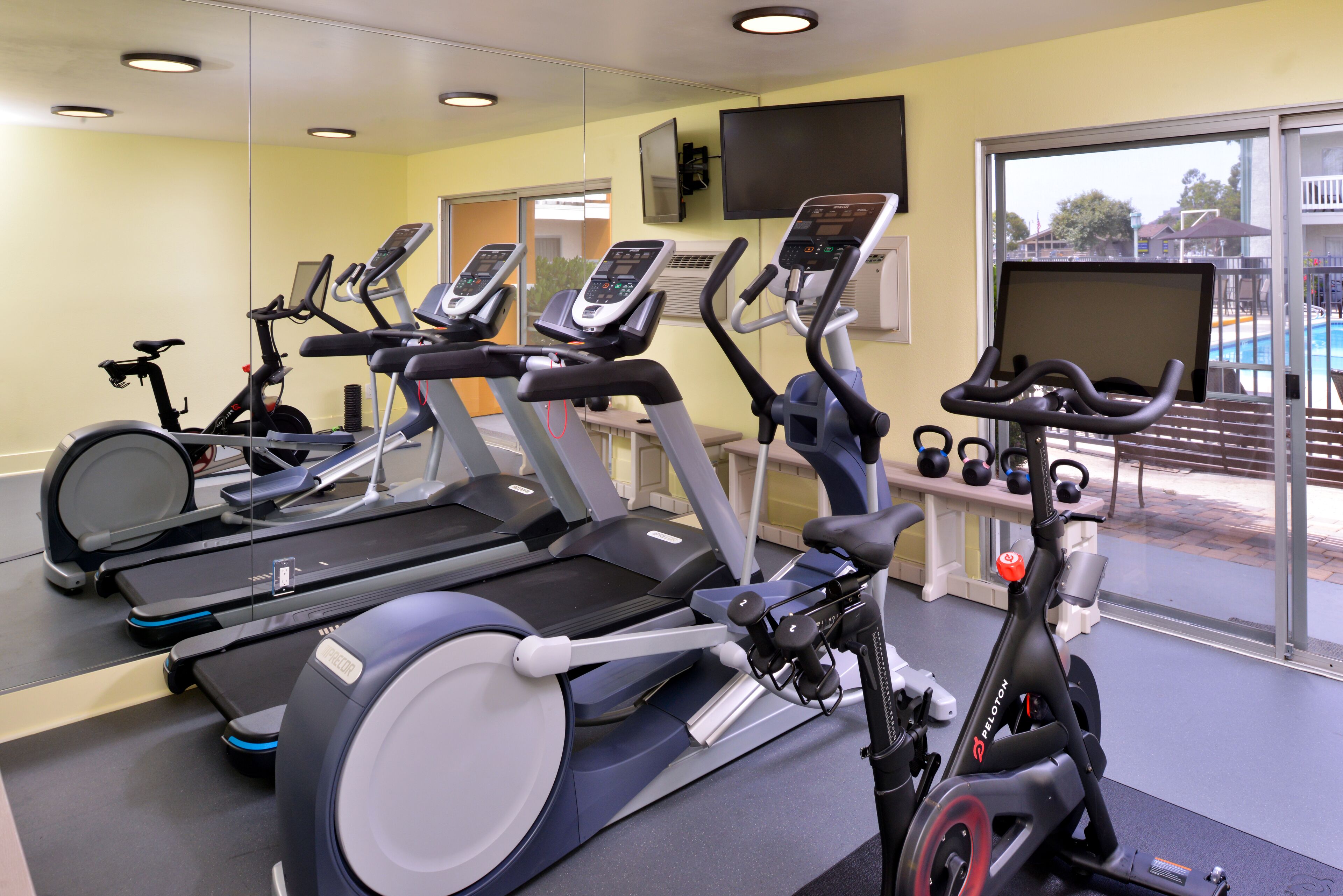 A gym with treadmills, an elliptical, and a stationary bike.