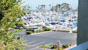 Un port de plaisance où sont amarrés de nombreux bateaux, un espace de stationnement et une vue sur l’océan.