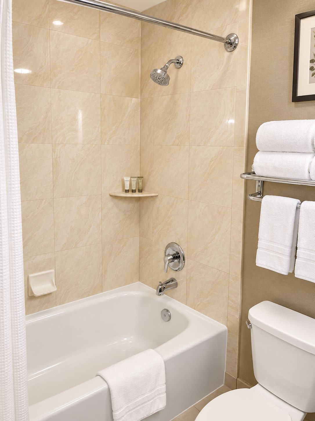 A bathroom with a bathtub, toilet, and shower area.