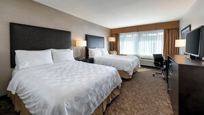 A hotel room with two beds, a desk with a computer, and a large window with curtains. - Pacific Stay Hotel (West Covina)