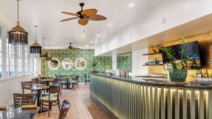 A restaurant with a bar area, dining tables, chairs, and ceiling fans. - Best Western Plus Hill House (Bakersfield)