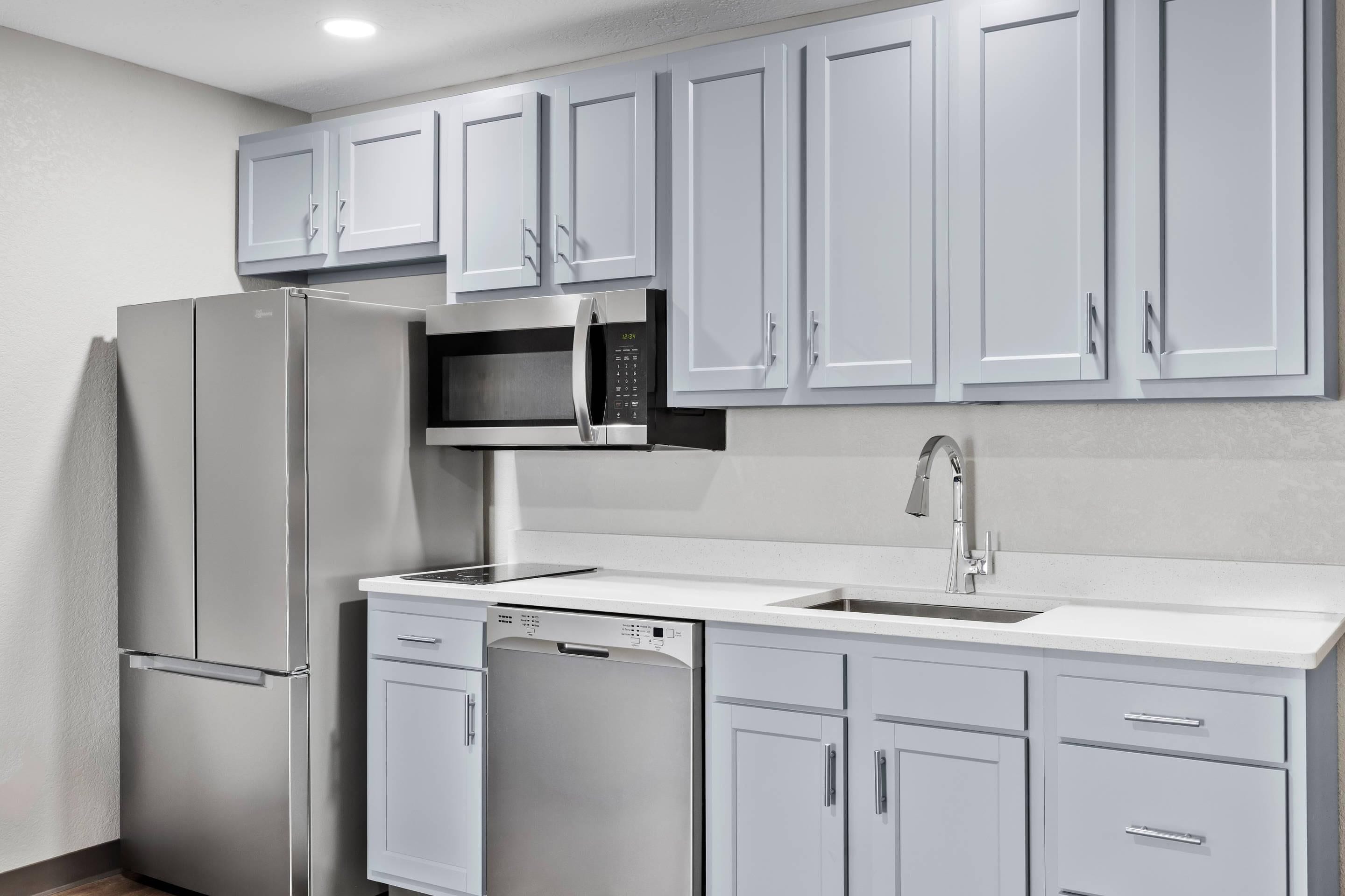 A modern kitchen with stainless steel appliances, a dishwasher, and a built-in microwave.