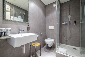 Un baño moderno con un lavamanos grande, inodoro y ducha.
