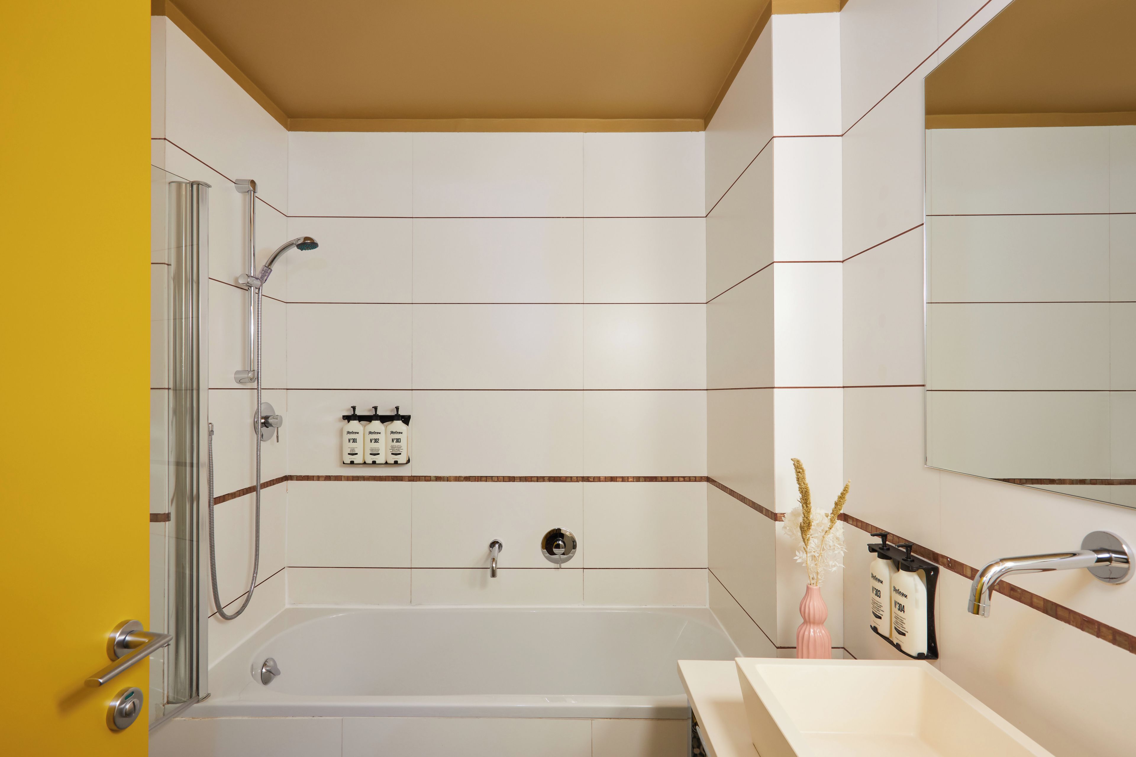 A modern bathroom with a bathtub, shower, and a vanity with a mirror.