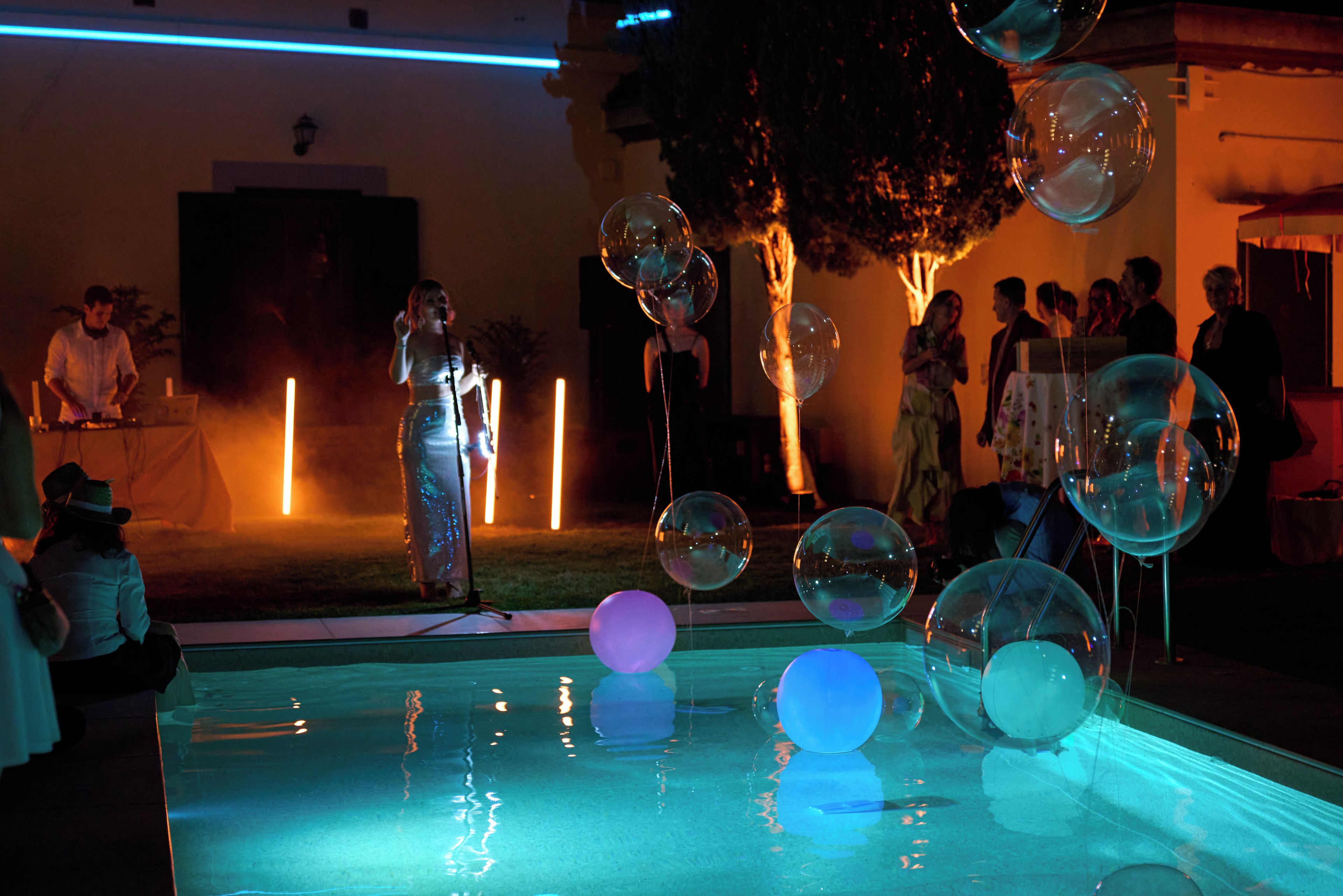 A pool with clear water and several transparent balloons.