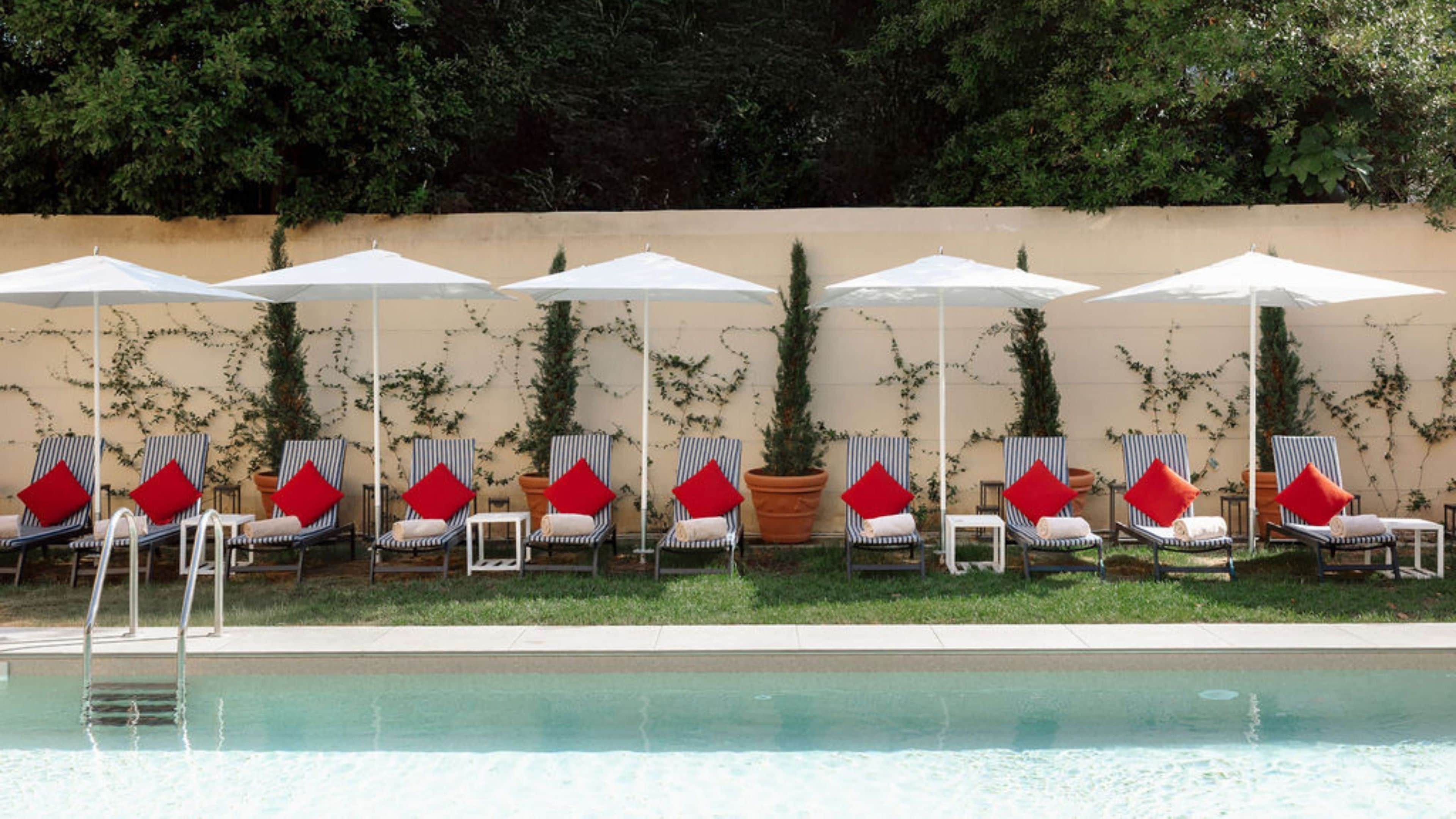 A poolside area with lounge chairs and umbrellas.