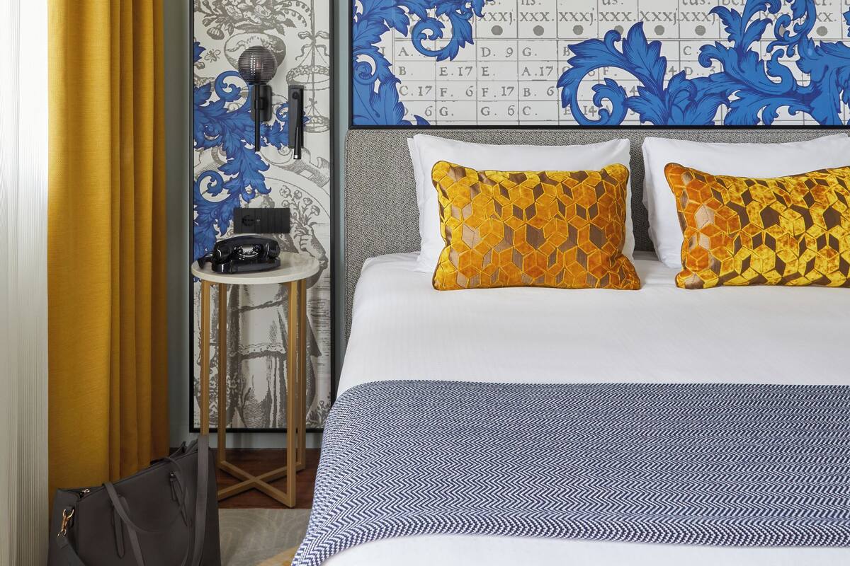Una habitación de hotel con una cama, un escritorio y una silla.