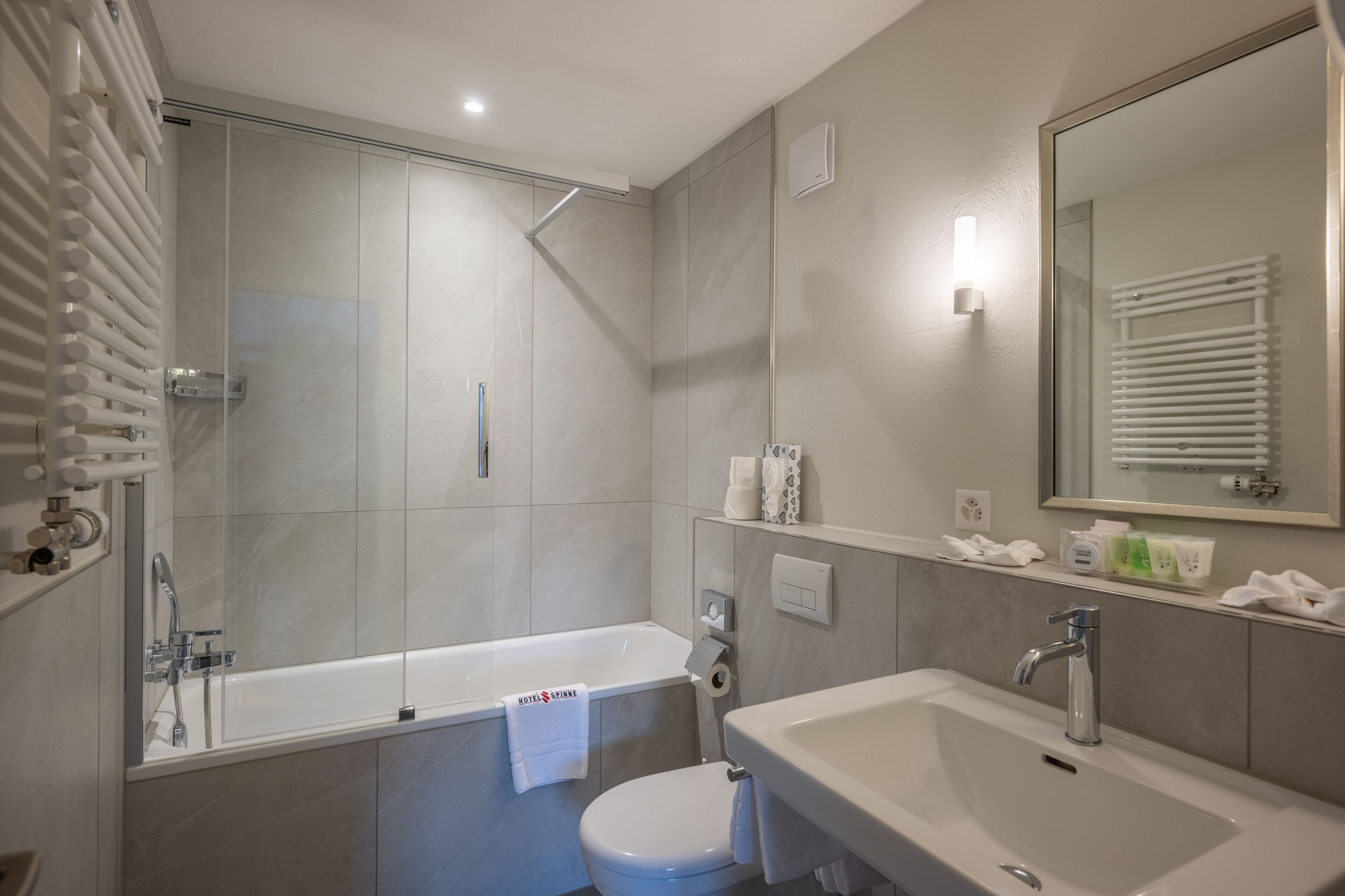 A modern bathroom with a bathtub, toilet, and sink.