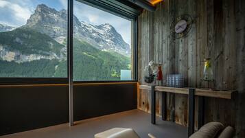 Una habitación moderna con un ventanal grande con vistas a un paisaje montañoso.