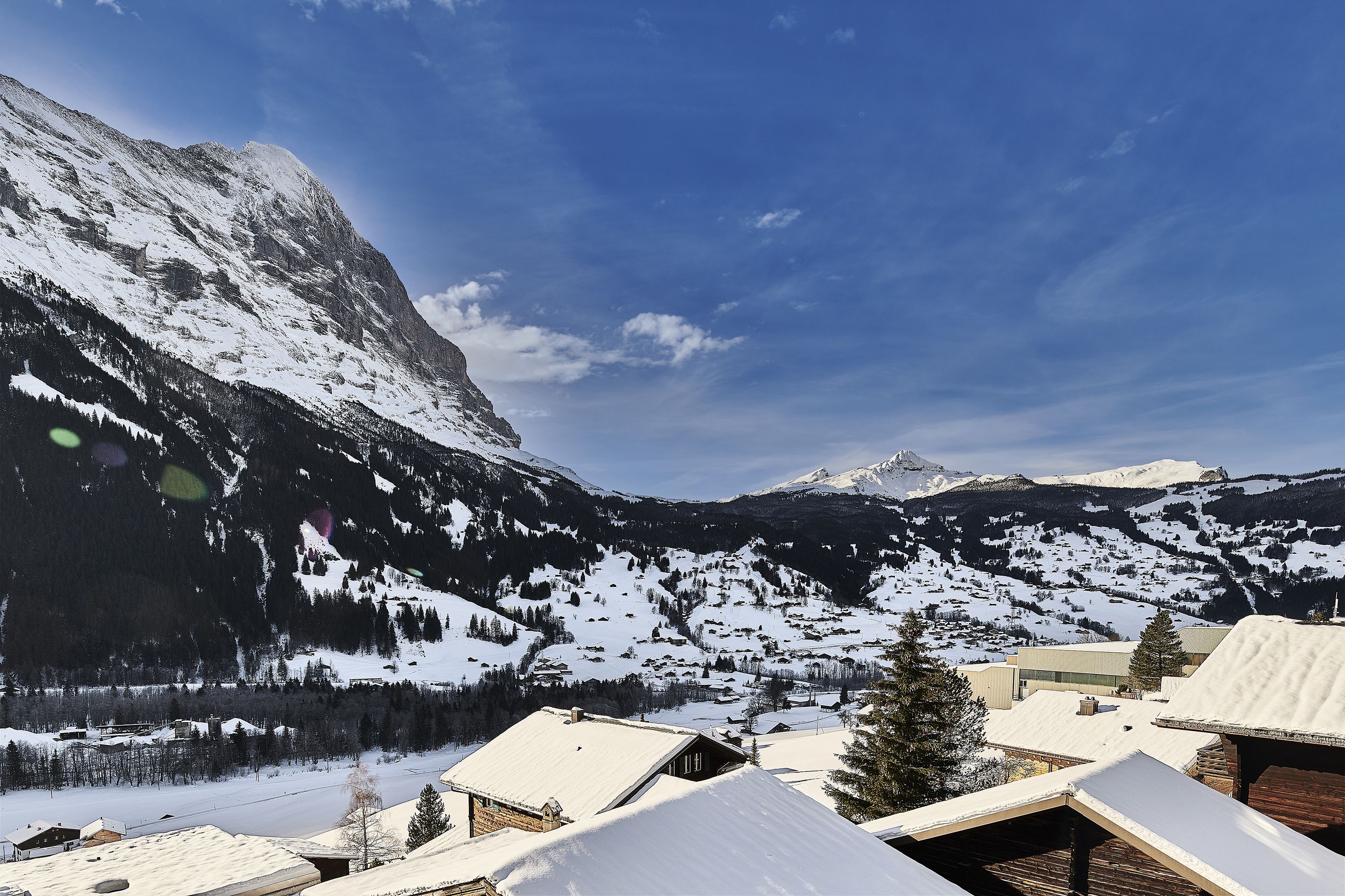 A mountainous landscape with snow-covered roofs and buildings, suggesting a winter setting.
