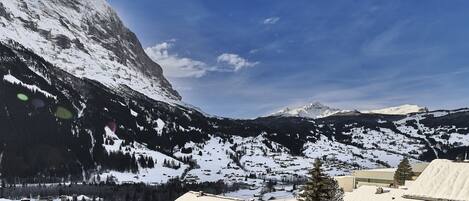 A mountainous landscape with snow-covered roofs and buildings, suggesting a winter setting.