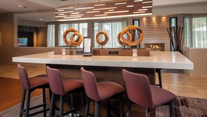 A modern bar area with a large island, bar stools, and a decorative wooden wall. - Courtyard by Marriott Dulles Airport Herndon/Reston (Herndon)