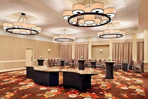 Conference room with a large, curved table and comfortable seating for meetings and presentations.