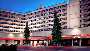 A hotel with a modern design, featuring a central entrance with a sign reading "Sheraton Cavalier." - Sheraton Cavalier Calgary Hotel (Calgary)