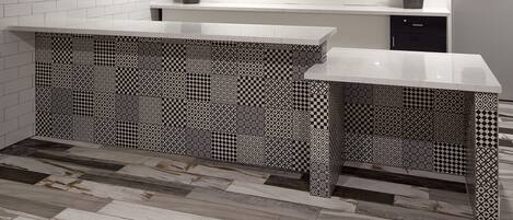 A kitchen with white subway tiles, a patterned backsplash, and a wooden floor.