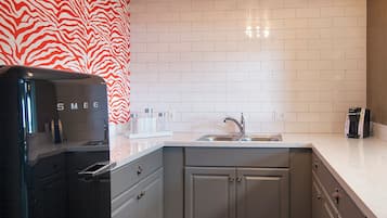 A modern kitchen with white subway tiles, a zebra-patterned wall, and a built-in refrigerator.