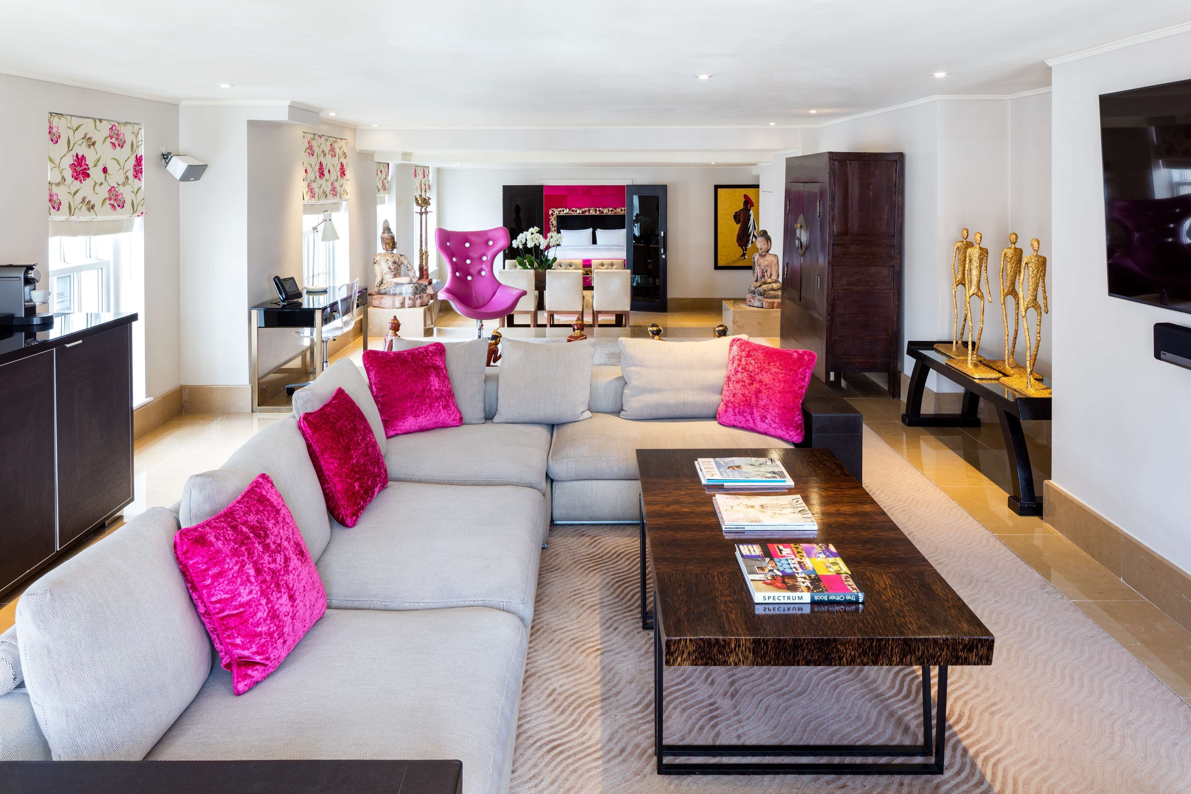 A modern living room with a sectional sofa, a coffee table, and a TV mounted on the wall.