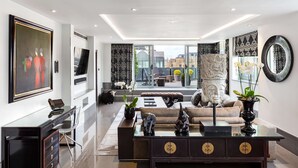 A modern living room with a glass coffee table, a sofa, and a desk with a chair. - The May Fair Hotel, Mayfair, London (London)