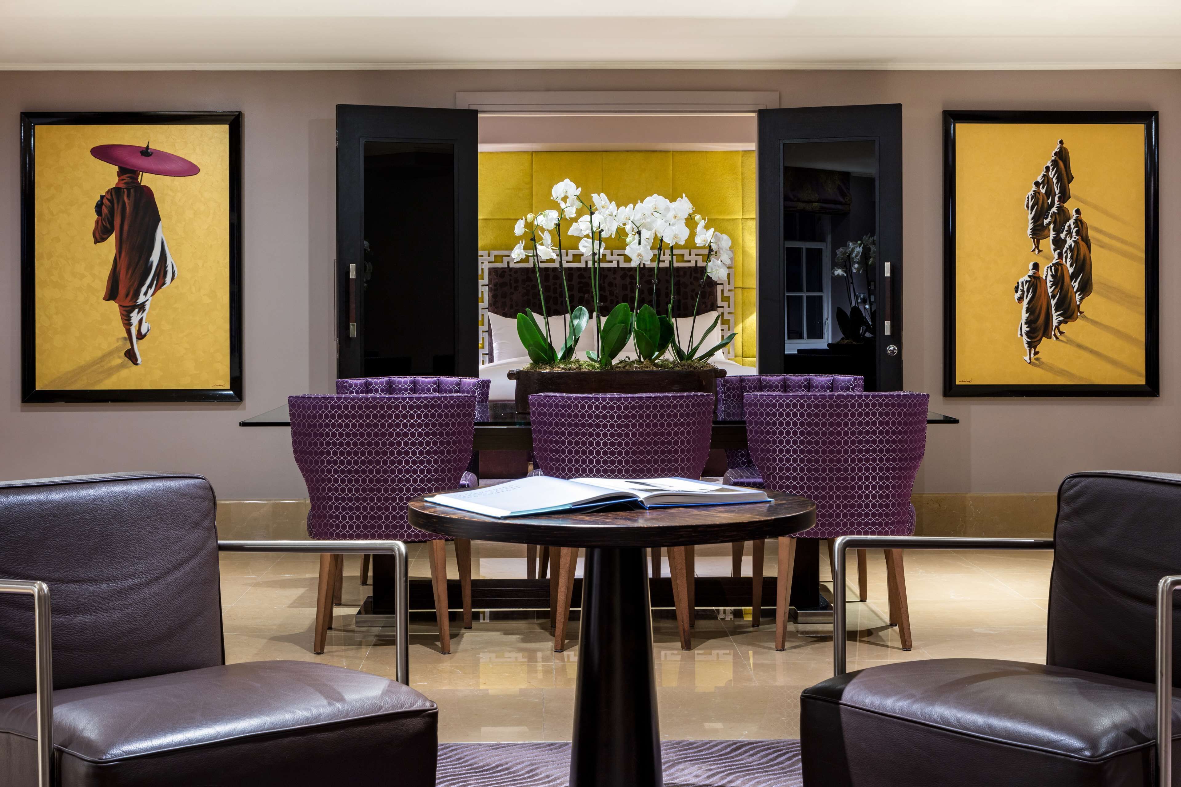 A lobby with a reception desk, purple patterned chairs, and artwork on the walls.